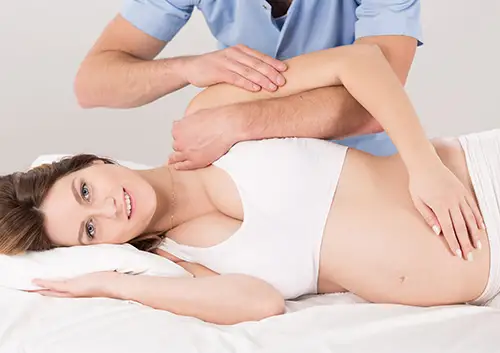 Village Family Clinic - Pregnant woman undergoing chiropractic adjustment